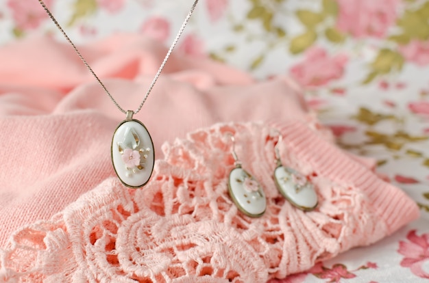 Earrings and pendant on a chain with an oval-shaped brass frame with a porcelain cabochon insert. Vintage decoration