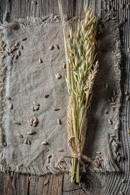 Ears with seeds on linen cloth as background