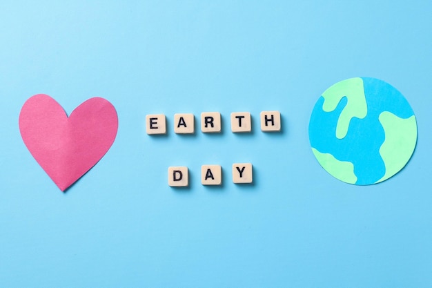 earth day words with globe made from paper and red heart shape. world earth day concept.