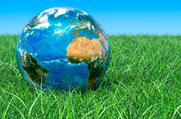 Photo earth globe on the green grass against blue sky 3d rendering