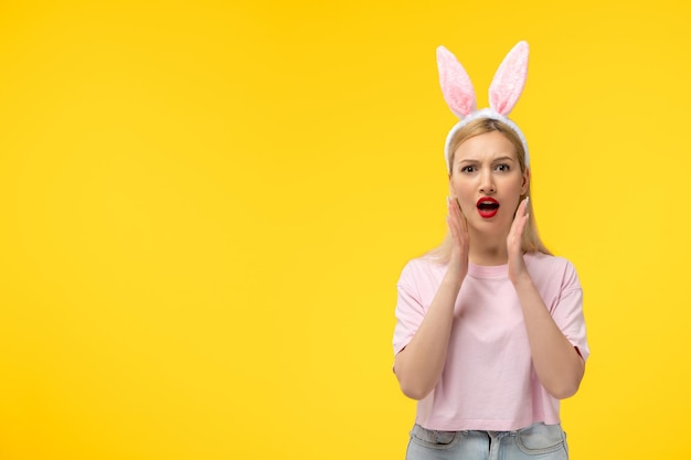 Easter adorable pretty young blonde girl with bunny ears annoyed and angry with hands on head