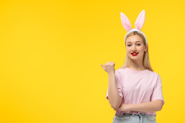 Easter adorable pretty young blonde girl with bunny ears holding fist up happily