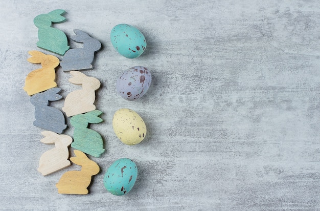 Easter background. Colorful pastel easter eggs and little cute wooden bunny 