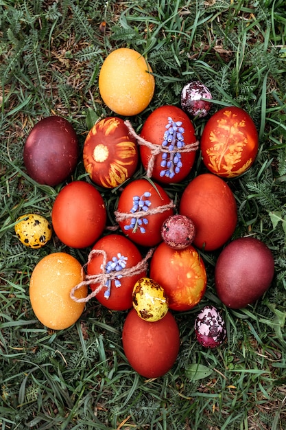 Easter background, multi-colored chicken and quail eggs on bright natural grass background.