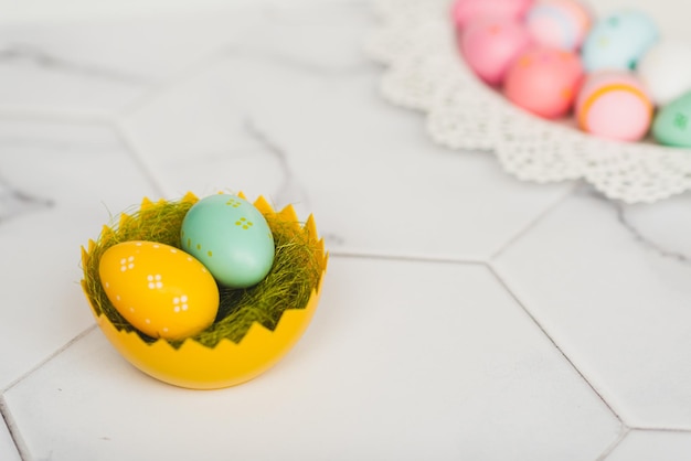 Easter background with colorful painted pink blue yellow Easter eggs and green grass Top view with copy space Easter holidays banner and header High quality photo