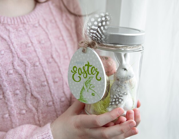 Easter background with a jar with a festive decor in childrens hands