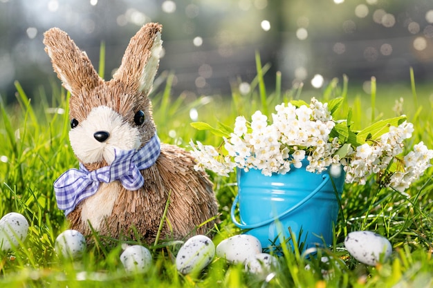 Easter background with rabbit eggs green grass and flowers