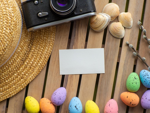 Easter background with straw hat photo camera colorful eggs and white rabbit