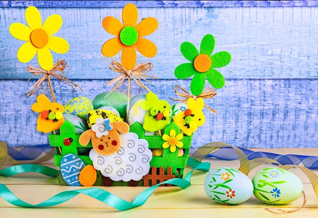 Photo easter basket with easter eggs flowers and decor in yellow green blue colors