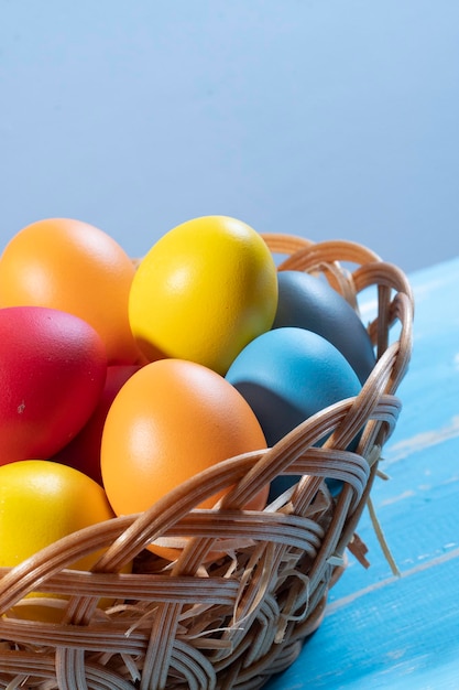 Easter basket with straw and colored eggs