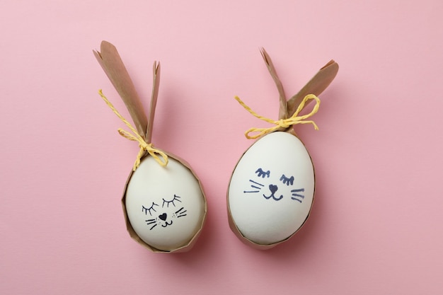 Easter bunnies made of eggs on pink background