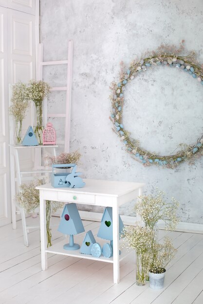 Photo easter bunny, blue birdhouses, bouquet flowers on kitchen table