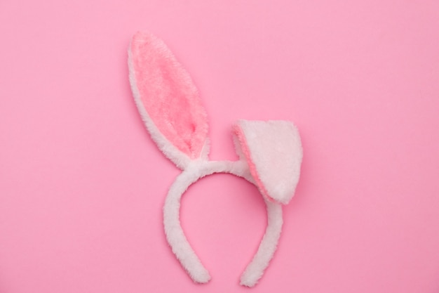 Easter bunny. Happy Easter holiday background concept.Flat lay colorful bunny egg with accessory to celebration on modern rustic pink pastel paper at home office desk.