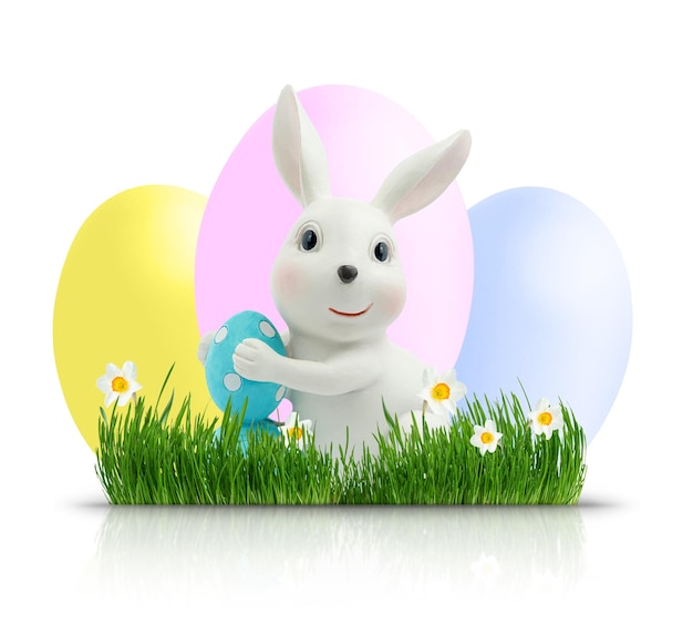 Easter bunny with coloured eggs on green grass isolated with clipping path