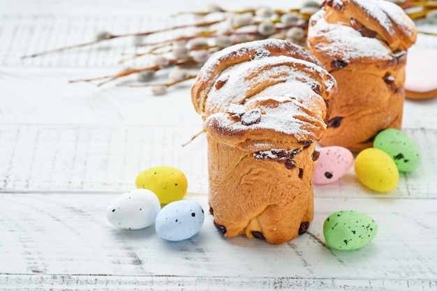 Easter cake, bright eggs, gingerbread and pussy willows branches on a festive Easter table. Greeting card.