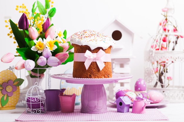 Easter cake on the cake stand and flowers, lilac desorations on the foreground