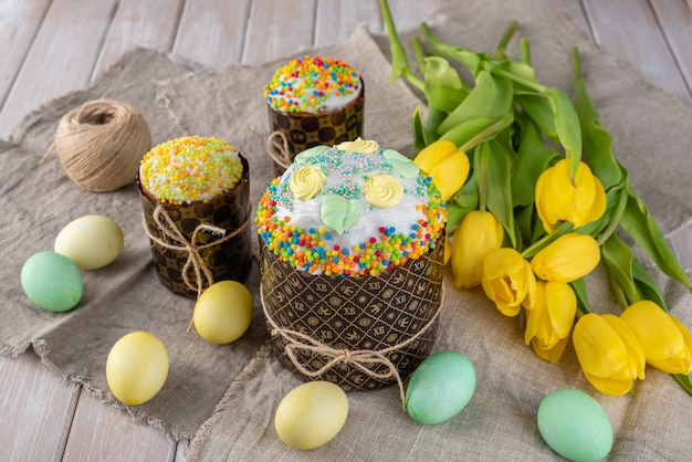 Easter cake, painted eggs with tulips on a wooden old rustic background.