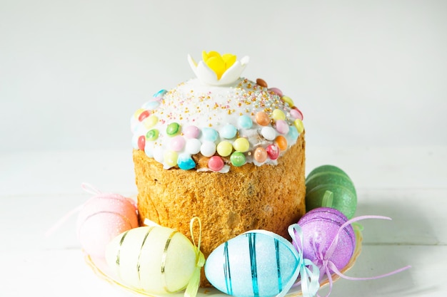 Easter cake with painted eggs on a platter in a gray interior Traditional festive food