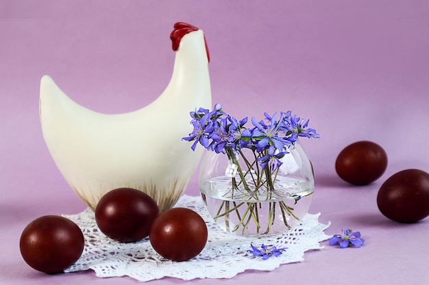 Easter card a bouquet of blue flowers painted eggs a chicken figurine on a pastel background