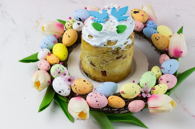 Easter card Kulich with sugar fudge in a wreath of tulips and eggs Marshmallow fudge with decoration