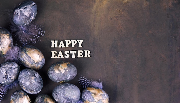 Easter card with a copy of the place for the text Purple blue and golden eggs on a dark background The color trends of 2022  very peri Natural dye Top view