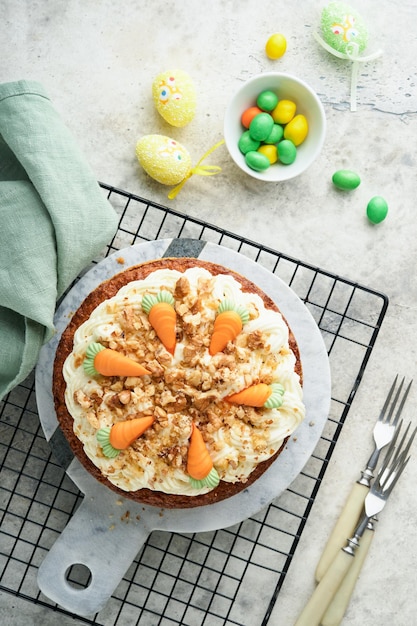 Easter Carrot cake with cream cheese frosting Delicious carrot cake with walnut and cream cheese frosting on gray concrete background table for festive dinner Traditional carrot cake Easter food