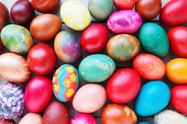 Easter colorful eggs close up Many colorful holiday eggs are stacked close to each other Boiled chicken eggs with floral and fantasy pattern Bright Easter background