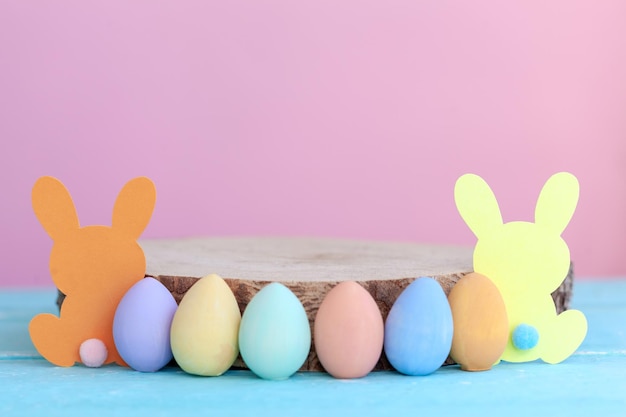 Easter colorful eggs with wooden empty platform on pink background Easter holiday mockup place for product presentation