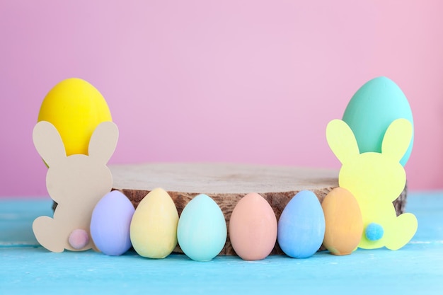 Easter colorful eggs with wooden empty platform on pink background