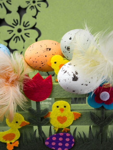 Easter composition colorful eggs with feathers decorative flowers and yellow chick