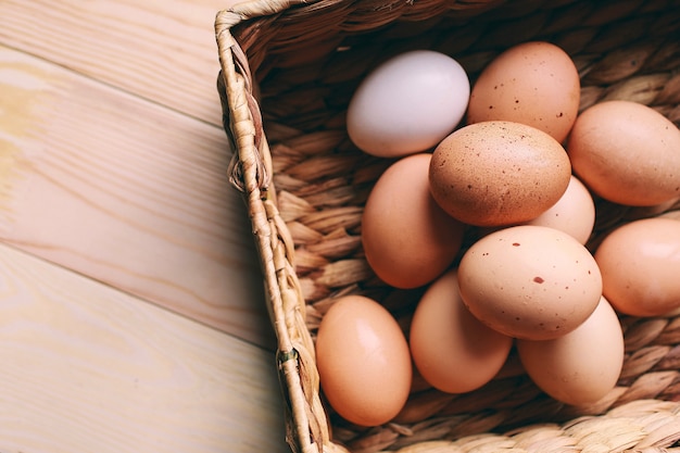 easter composition Easter eggs lie in an egg box next to green branches on a wooden light background easter concept photo from above