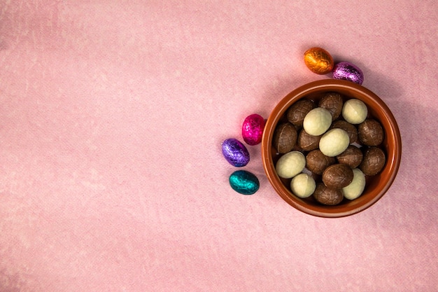 Easter composition with chocolate easter eggs on pink background space for text top view happy easte