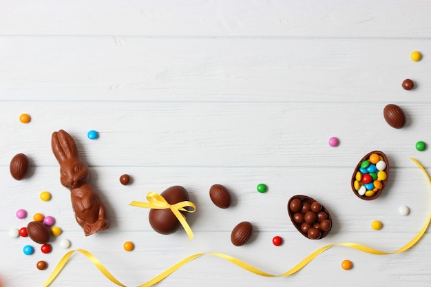 Easter composition with chocolate eggs and chocolate rabbit on wooden background, place for text. easter sweets. High quality photo