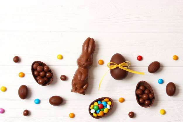 Easter composition with chocolate eggs and chocolate rabbit on wooden background