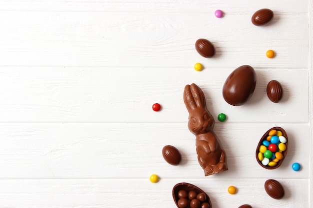 Easter composition with chocolate eggs and chocolate rabbit on wooden background