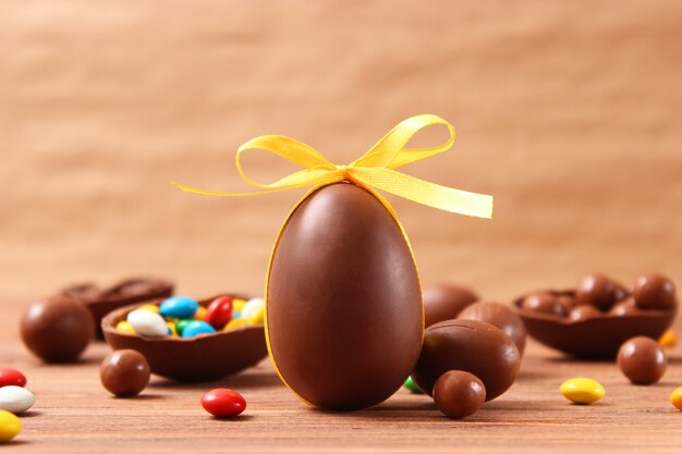 Easter composition with chocolate eggs and chocolate rabbit on wooden background