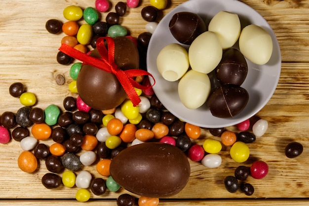 Easter composition with chocolate eggs on wooden background