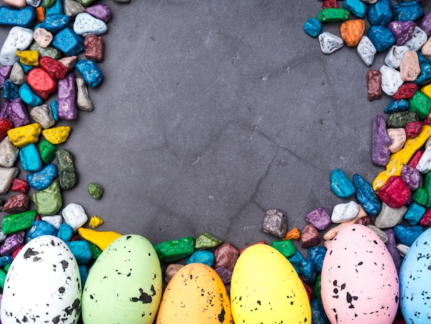 Easter composition with colored eggs and sweets on concreten background space for text