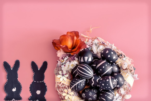 Easter composition with eggs and the Easter Bunny on a pink wall