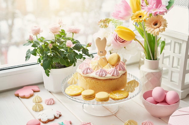 Easter composition with pink eggs, ceramic bunny and flowers in a vase