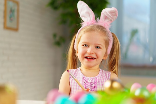 Easter concept. Toddler blonde happy  girl with bunny ears