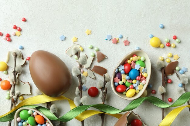 Easter concept with chocolate eggs on white textured wall