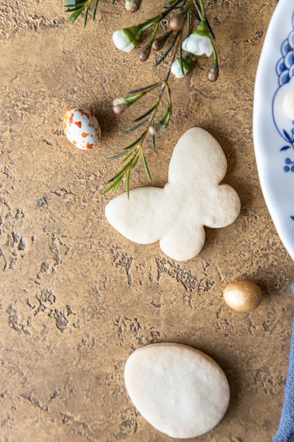 Easter cookies on a ceramic plate with floral decor and candies shaped eggs