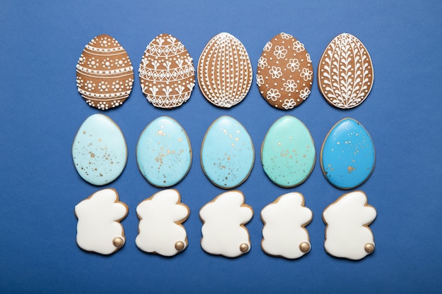 Easter cookies on a plate on a blue surface. Easter bunny. Easter eggs.