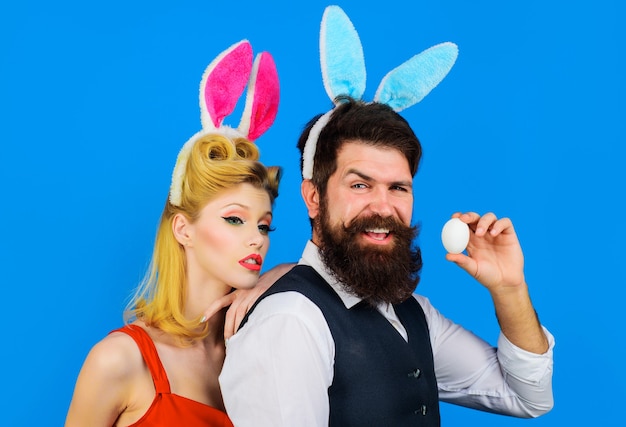 Easter couple. Family celebrating Easters. Handsome bearded man and funny woman. Bunny ears. Love.