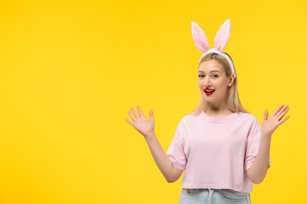 Easter cute young blonde girl wearing pink bunny ears waving hands happily