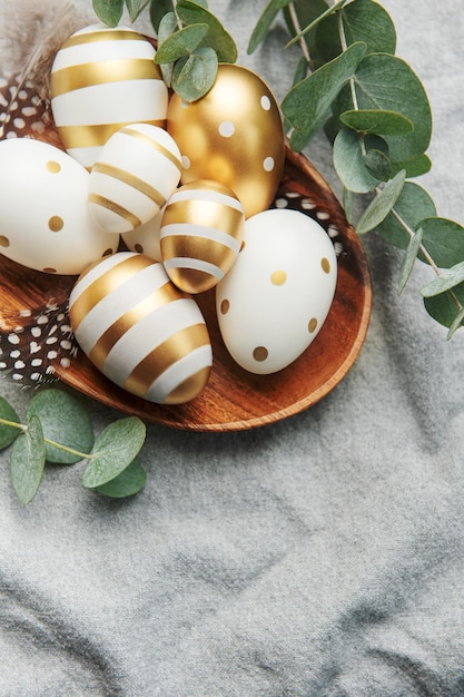 Easter decor Colored Easter eggs on a wooden plate on the table The concept of preparing for the celebration