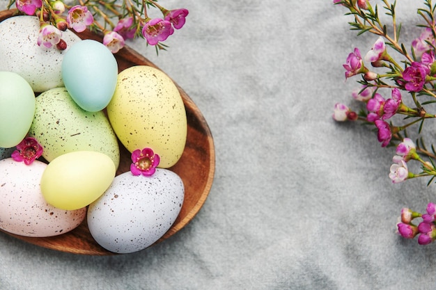 Easter decor Colored Easter eggs on a wooden plate on the table