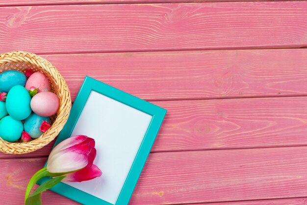 Easter decoration with tulips, eggs and blank frame. Top view