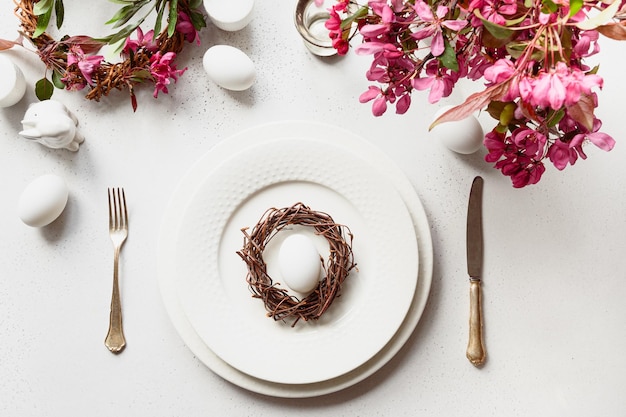 Easter dinner with eggs bunny festive tableware and tulips on white